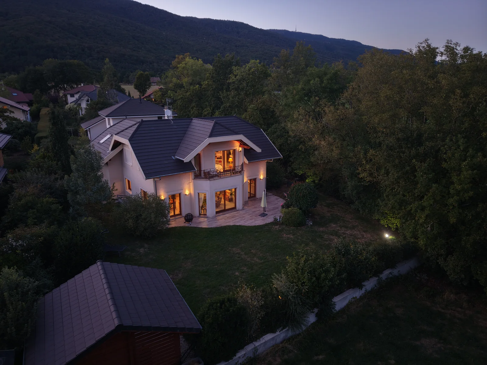 Villa éclairée à la tombée du jour, photographiée depuis les airs